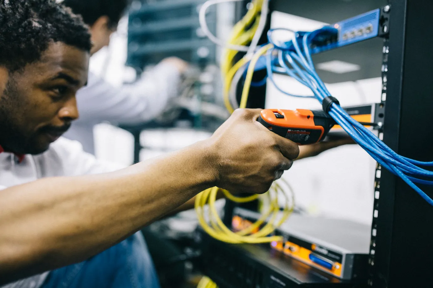 Technician terminating structured cabling in a network rack during an installation