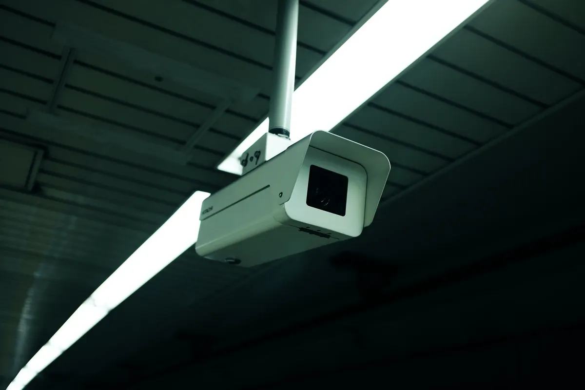 Ceiling-mounted commercial surveillance camera in a low-light interior