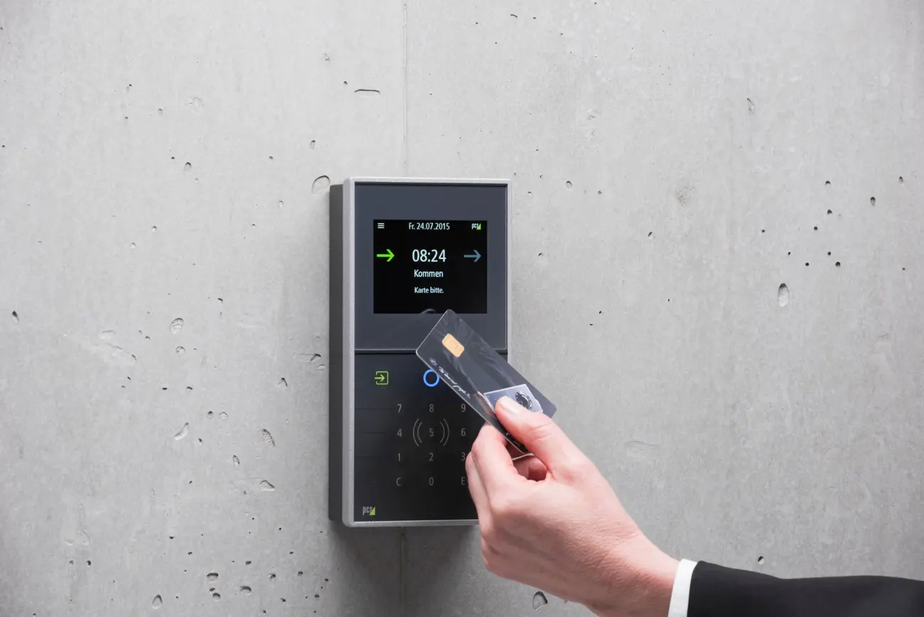 Employee badging in at a wall-mounted access control reader